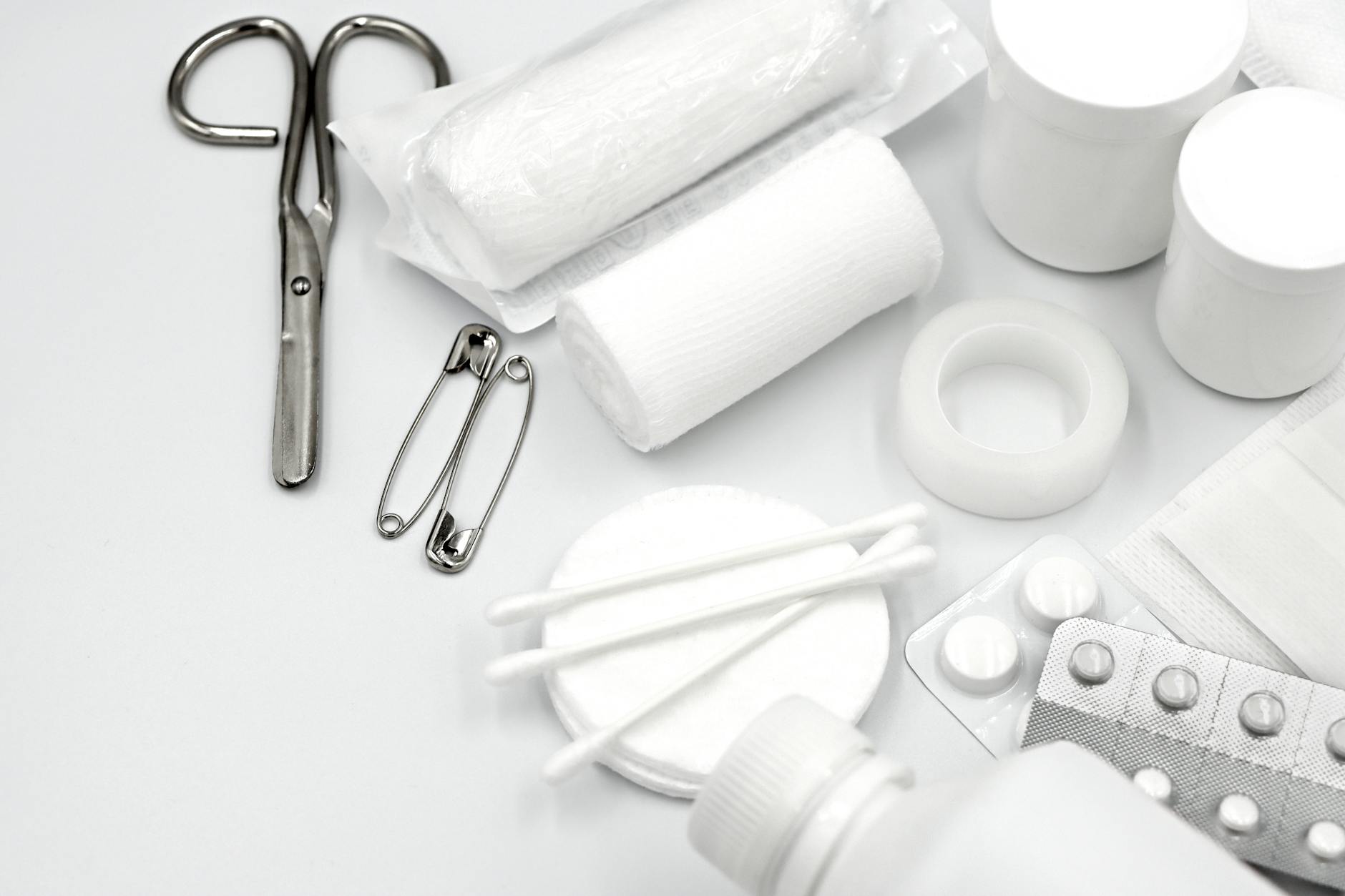 First aid kit open with bandages and medical supplies next to a wilderness trail guide