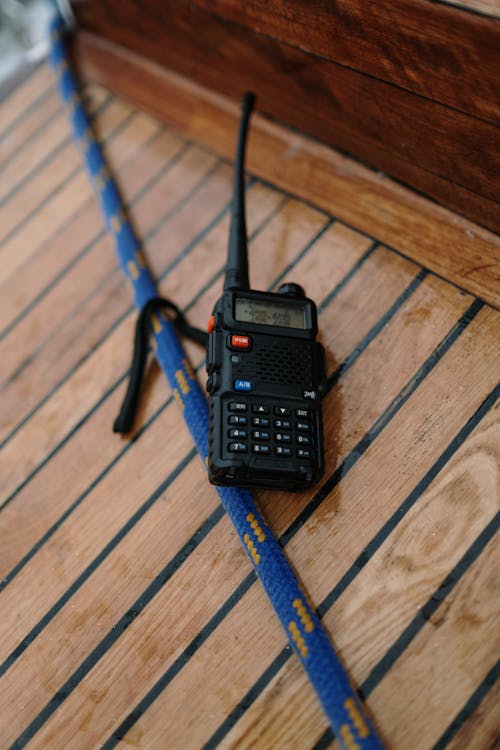 Hand-crank emergency radio with solar panel sitting on a wooden surface outdoors