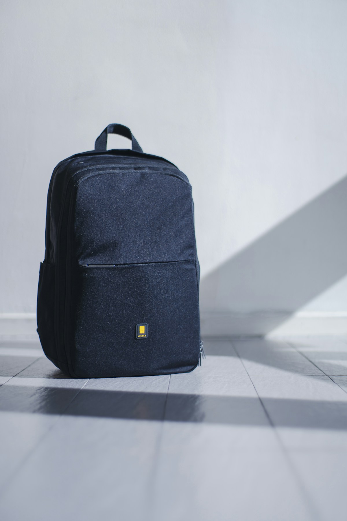Tactical backpack open with survival gear and emergency supplies laid out on a wooden floor