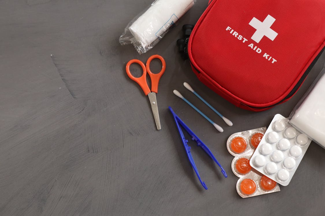 A well-organized first aid kit with trauma supplies laid out on a wooden table