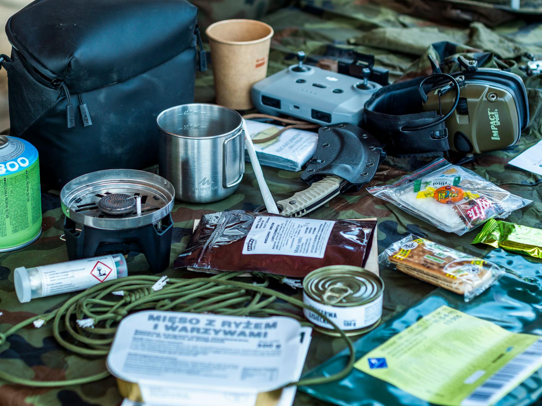 Fully packed bug out bag weighed on a scale next to gear laid out on a table