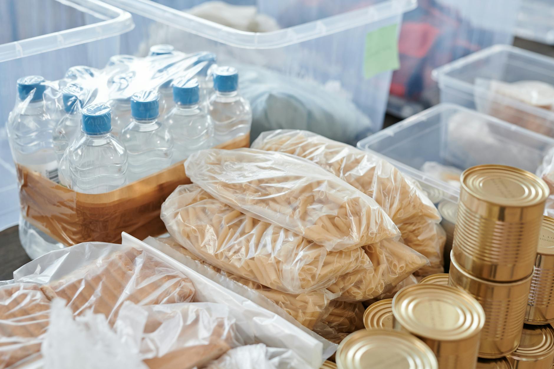 Stack of water storage containers and jugs in a basement emergency supply area