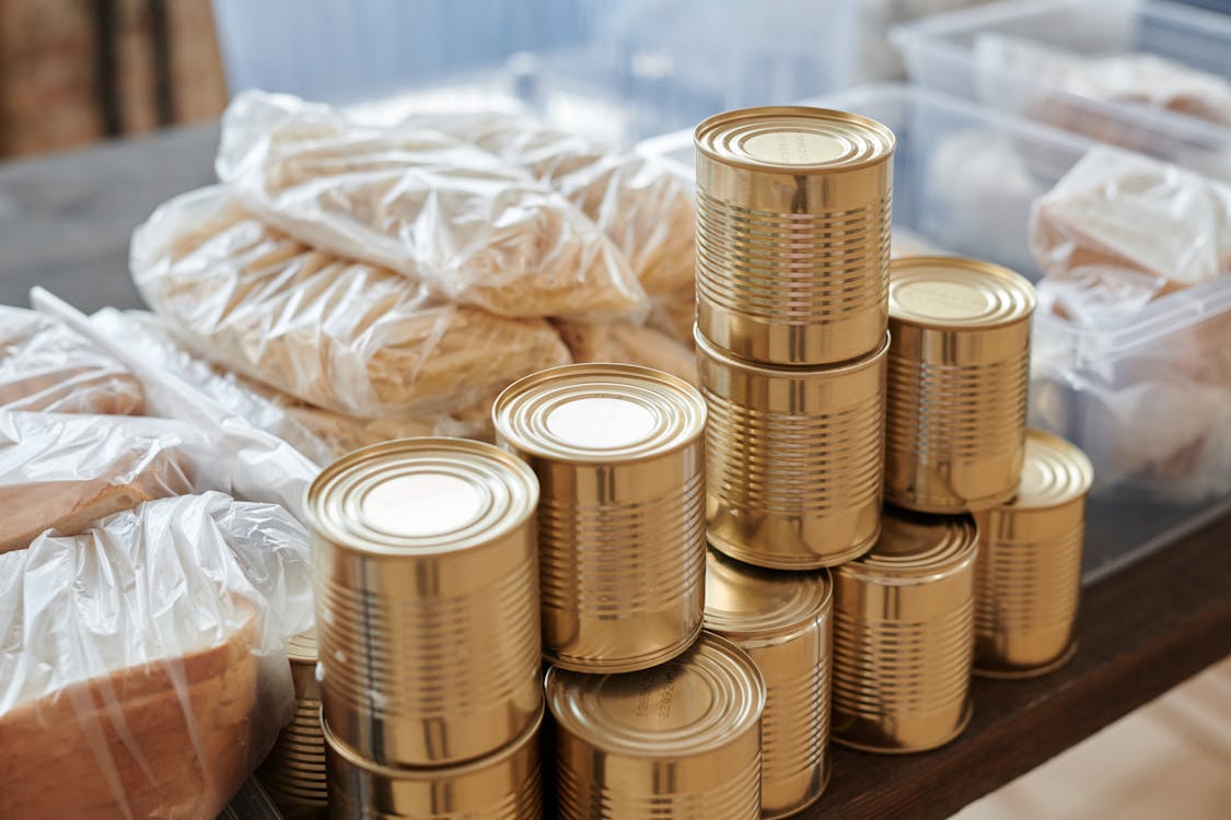 Organized pantry shelves with labeled mason jars, canned goods, and dry goods in mylar bags