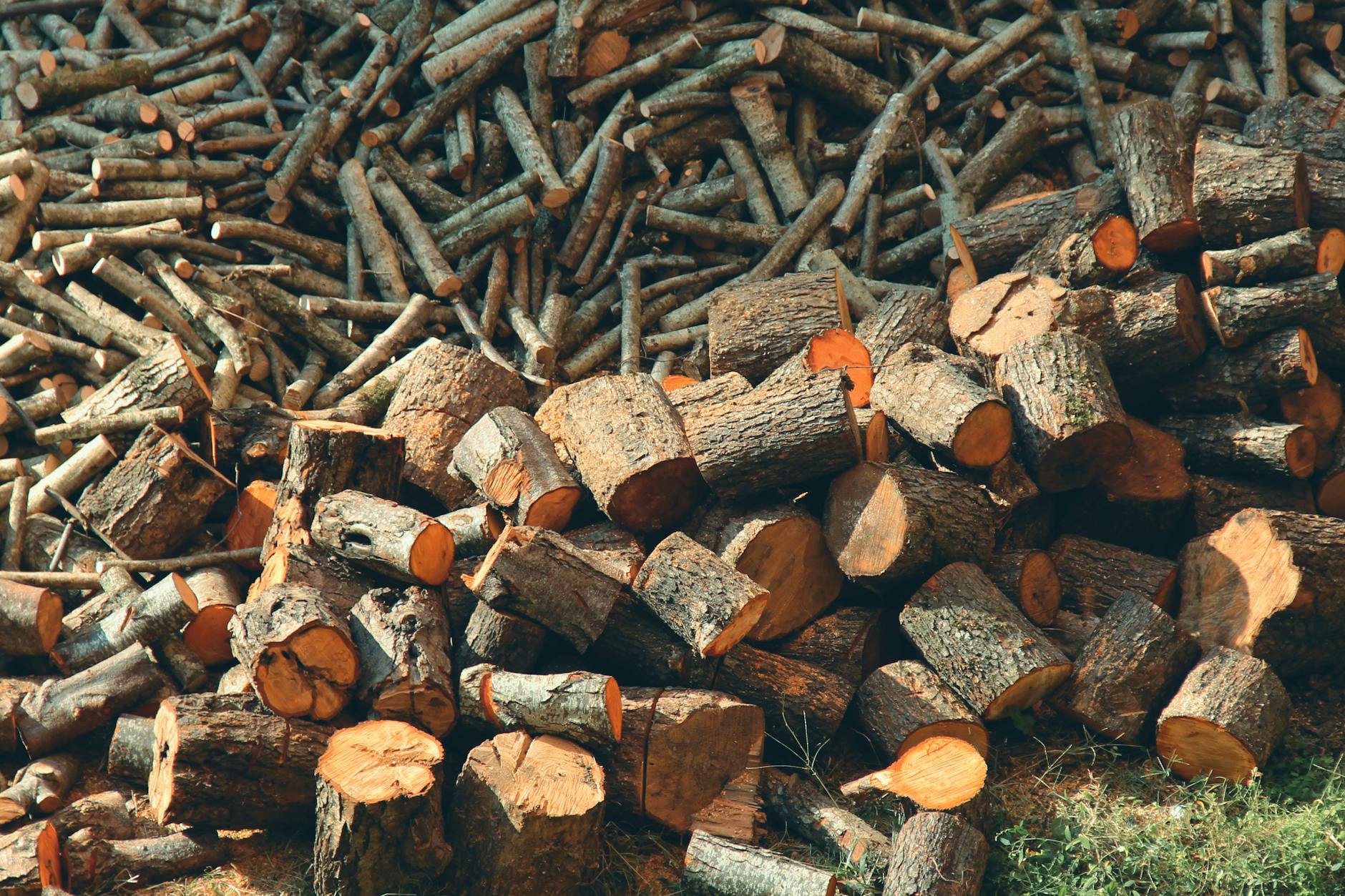Large stack of split firewood neatly stacked outside a rural cabin for winter