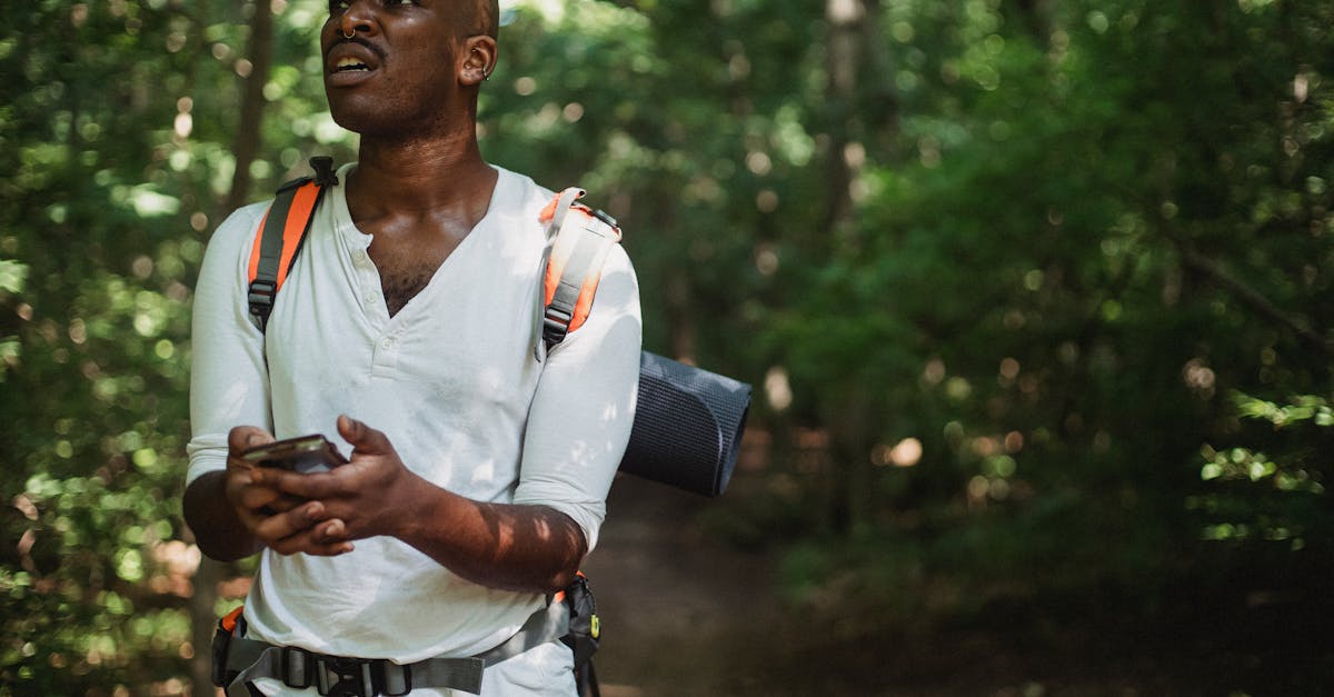 Handheld GPS device with topographic map display held by hiker in forested backcountry terrain