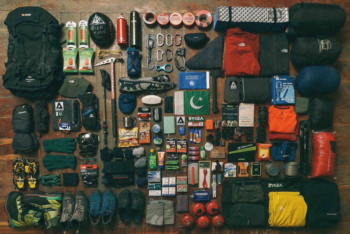 Lightweight tactical backpack with minimal ultralight survival gear laid out on ground