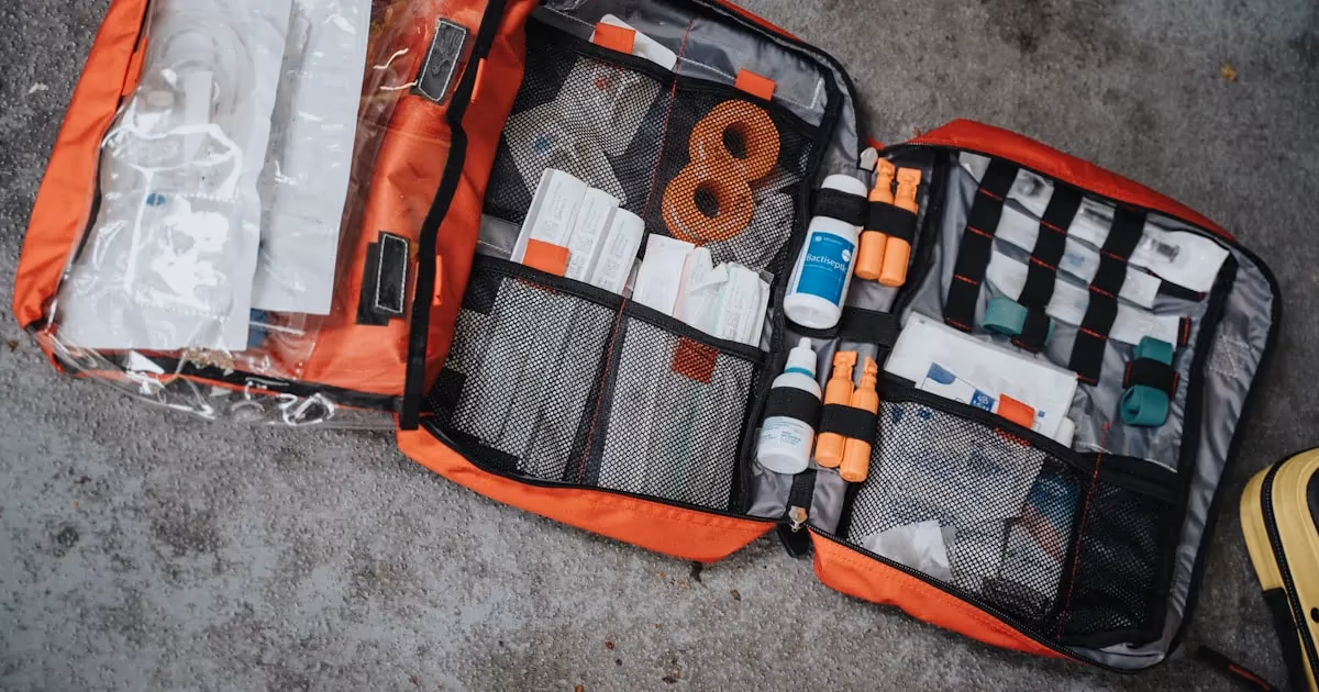A truck bed with organized emergency supplies including jumper cables, water jugs, and a first aid kit